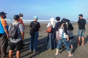 Pihak keluarga saat mencari korban yang terseret ombak.